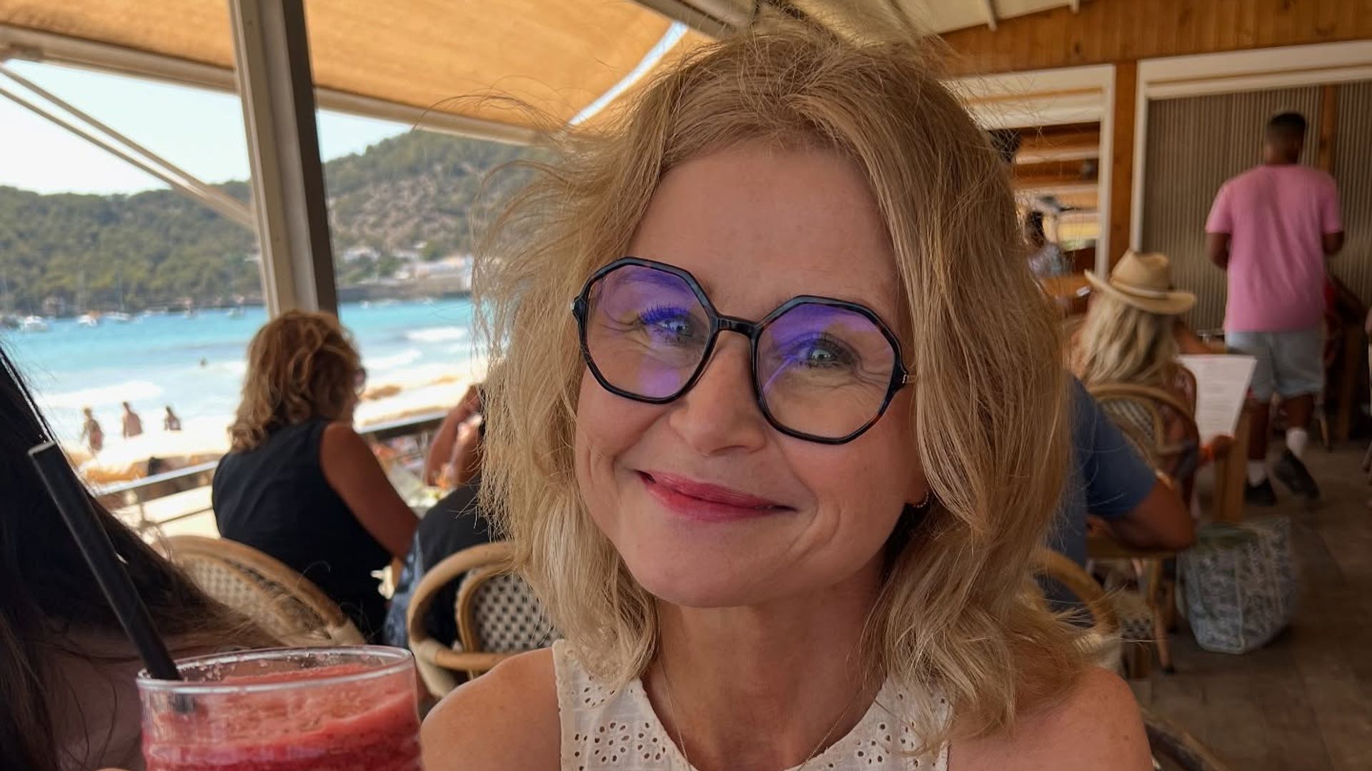 Woman in her 50s smiling at a beach club