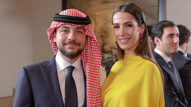 Crown Prince Hussein standing with Princess Rajwa, who wears a yellow dress