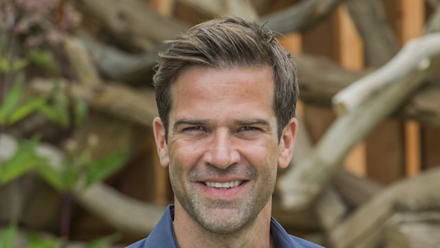 man posing for photo in garden