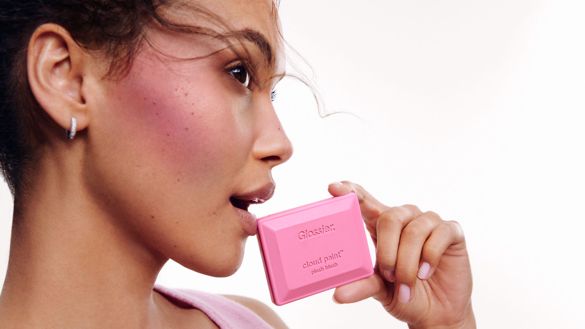 Glossier product image with woman holding product 