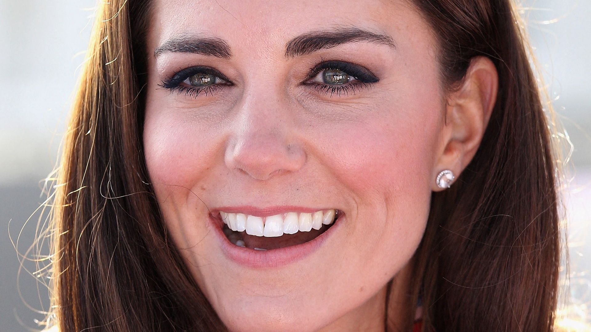 Kate Middleton smiling as she wears the Team GB Official Supporter's Scarf for the London 2012 Olympic Games before meeting the British hockey team at the Riverside Arena during a visit to the Olympic Park in London