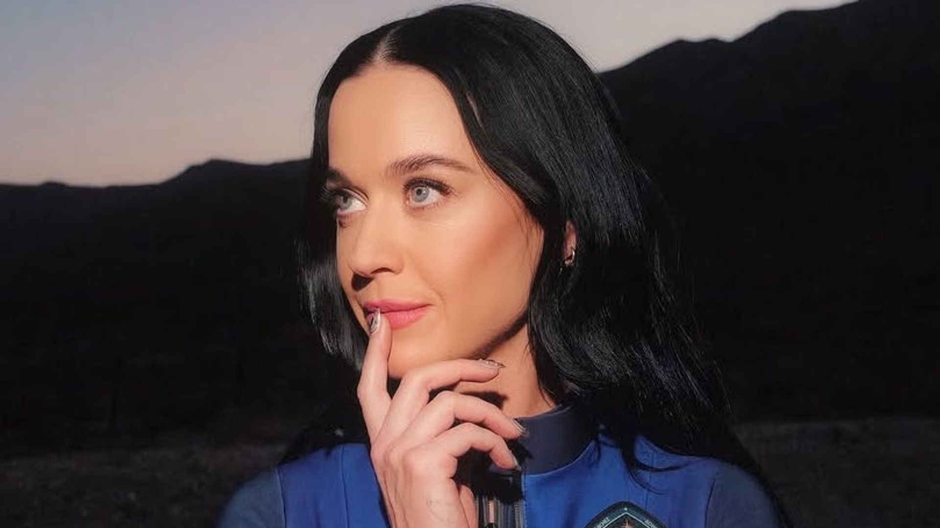 Katy Perry looks into the distance wearing space suit