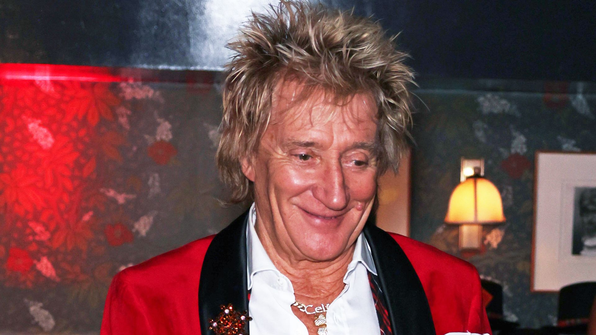 Rod Stewart in a red jacket and white shirt