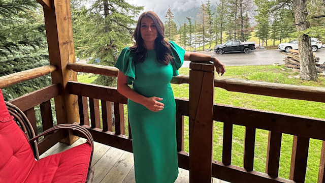 woman in a green dress on a wooden deck