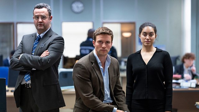 three people standing in office
