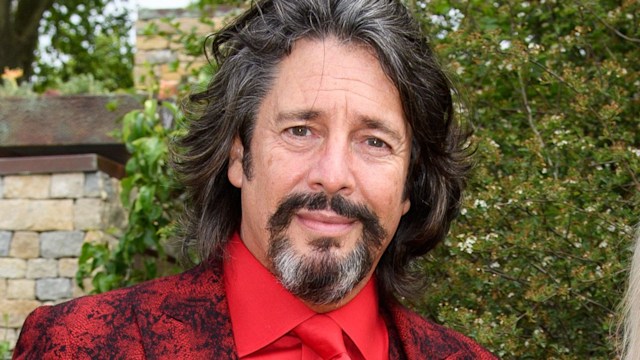 Laurence Llewelyn-Bowen in a red suit with his wife Jackie in a red leather jacket