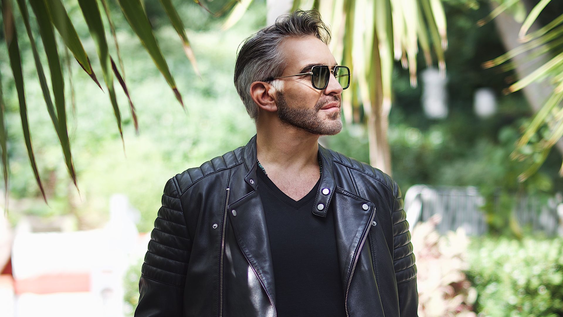 Martyn Lawrence posing with sunglasses outside 