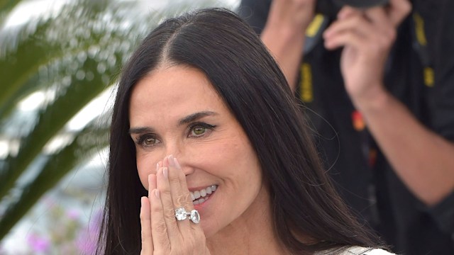 Demi Moore with hands held to face