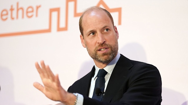 Prince William moving his hands around in a black suit