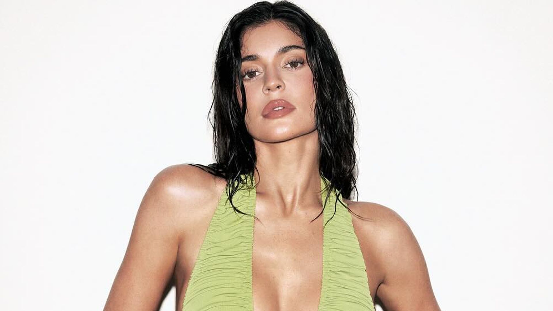 Kylie Jenner poses in a green plunge dress