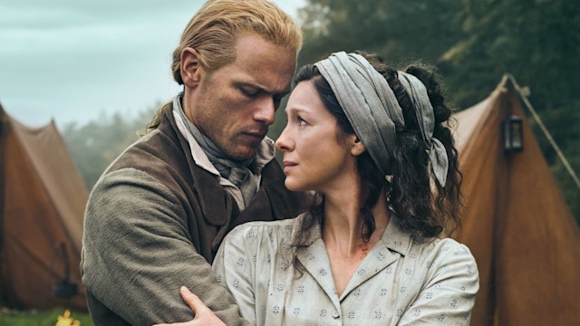 Sam Heughan and Caitriona Balfe embrace and stare at each other as their characters in Outlander Season Seven