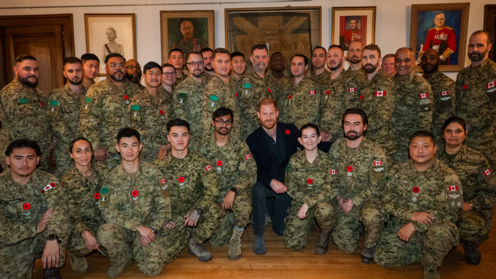 Prince Harry crouching with a group of soldiers