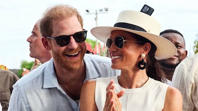 Prince Harry and Meghan wearing sunglasses and smiling in Colombia