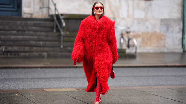 COPENHAGEN, DENMARK - JANUARY 30: Nina Suess wears sunglasses, earrings, a bold red oversized fluffy faux fur long coat, stirrup leggings, pointed shiny shoes, outside Aeron,  during the Copenhagen Fashion Week AW24 on January 30, 2024 in Copenhagen, Denmark. (Photo by Edward Berthelot/Getty Images)