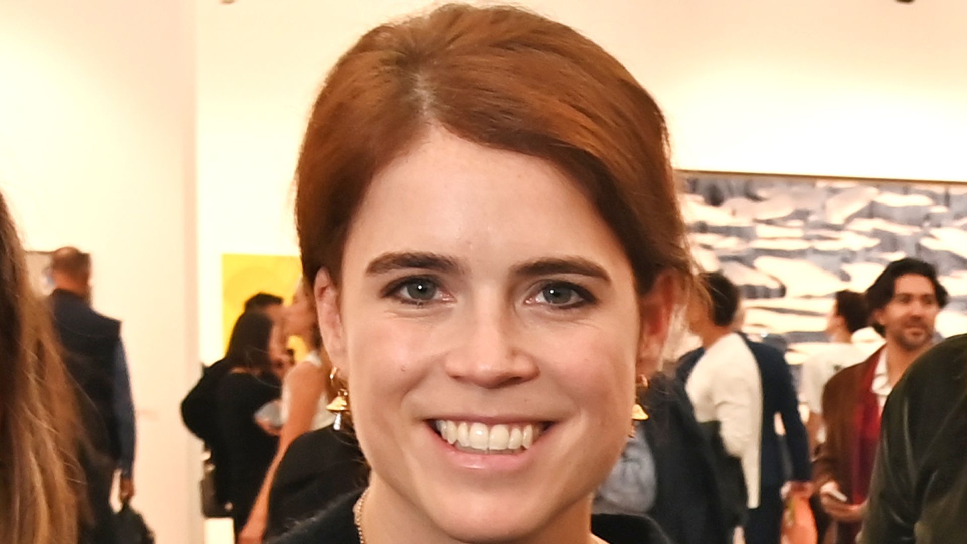 Princess Eugenie in black sweater and skirt and Michael Walker posed at gallery