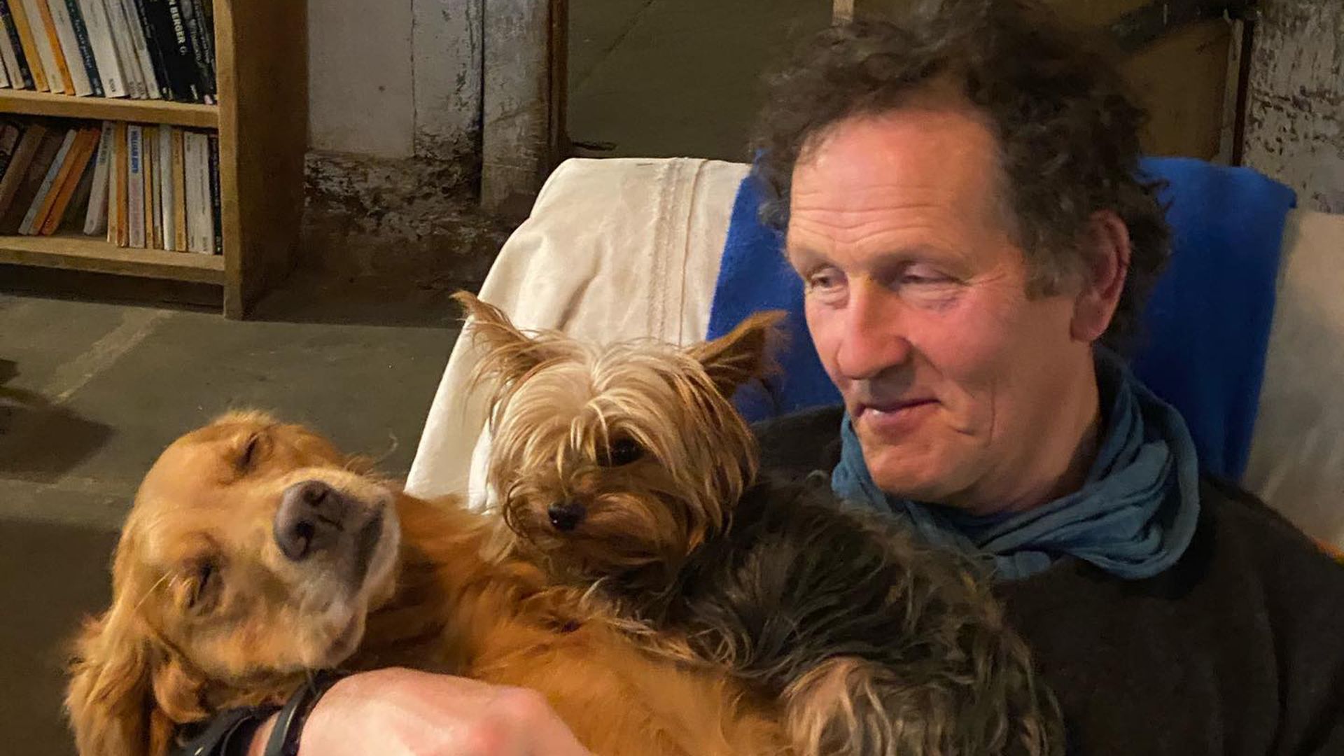 Monty Don cuddling two of his dogs at home