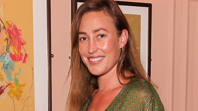 Tatiana Mountbatten in a green dress against a pink wall