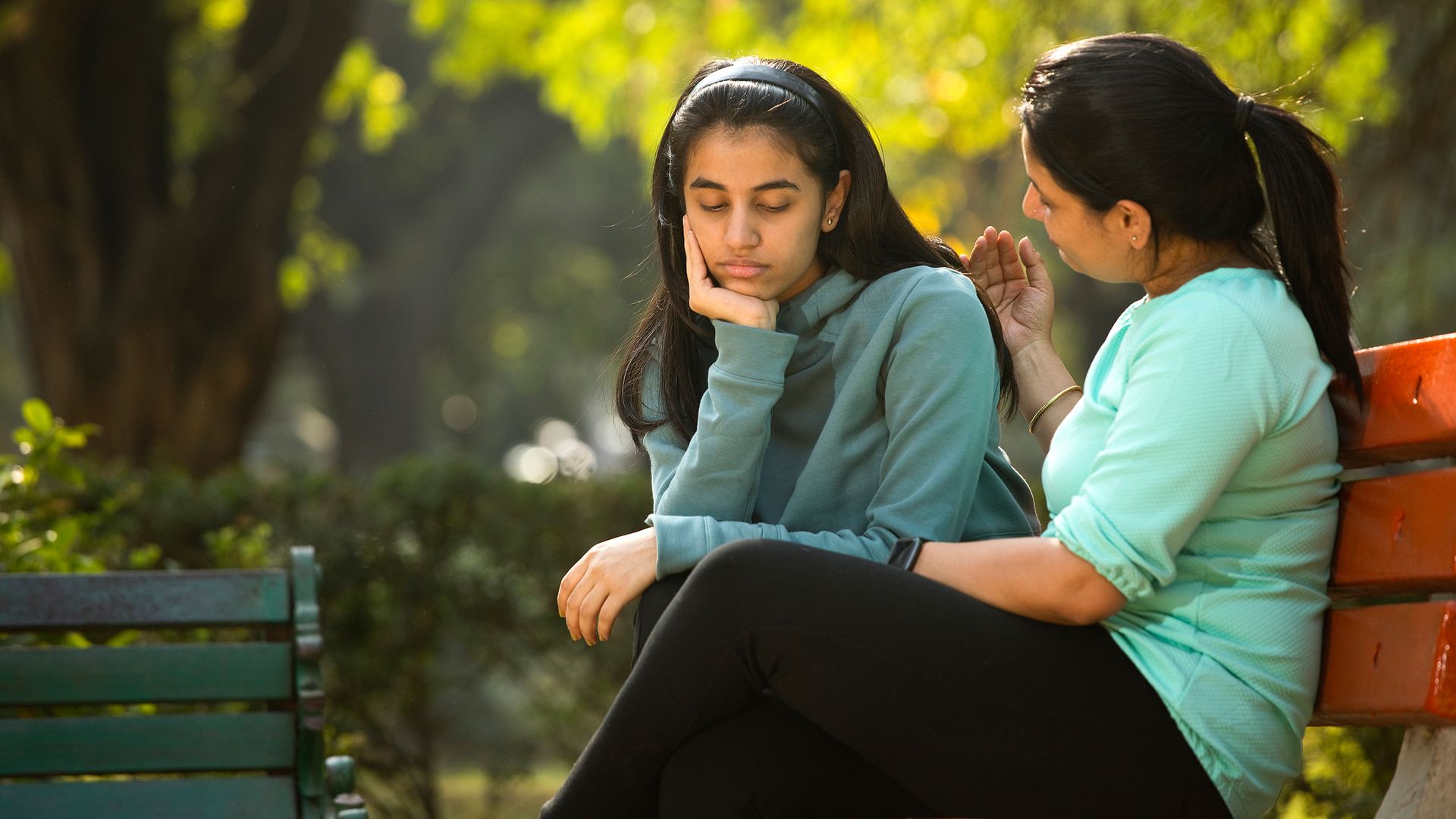 Mother comforting her daughter in a park