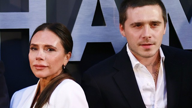 Victoria Beckham in a white suit with her son Brooklyn