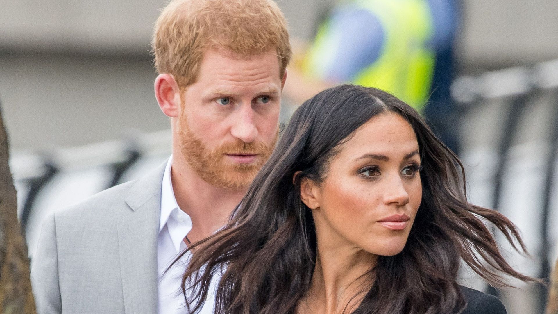 Prince Harry raising his eyebrows behind Meghan Markle