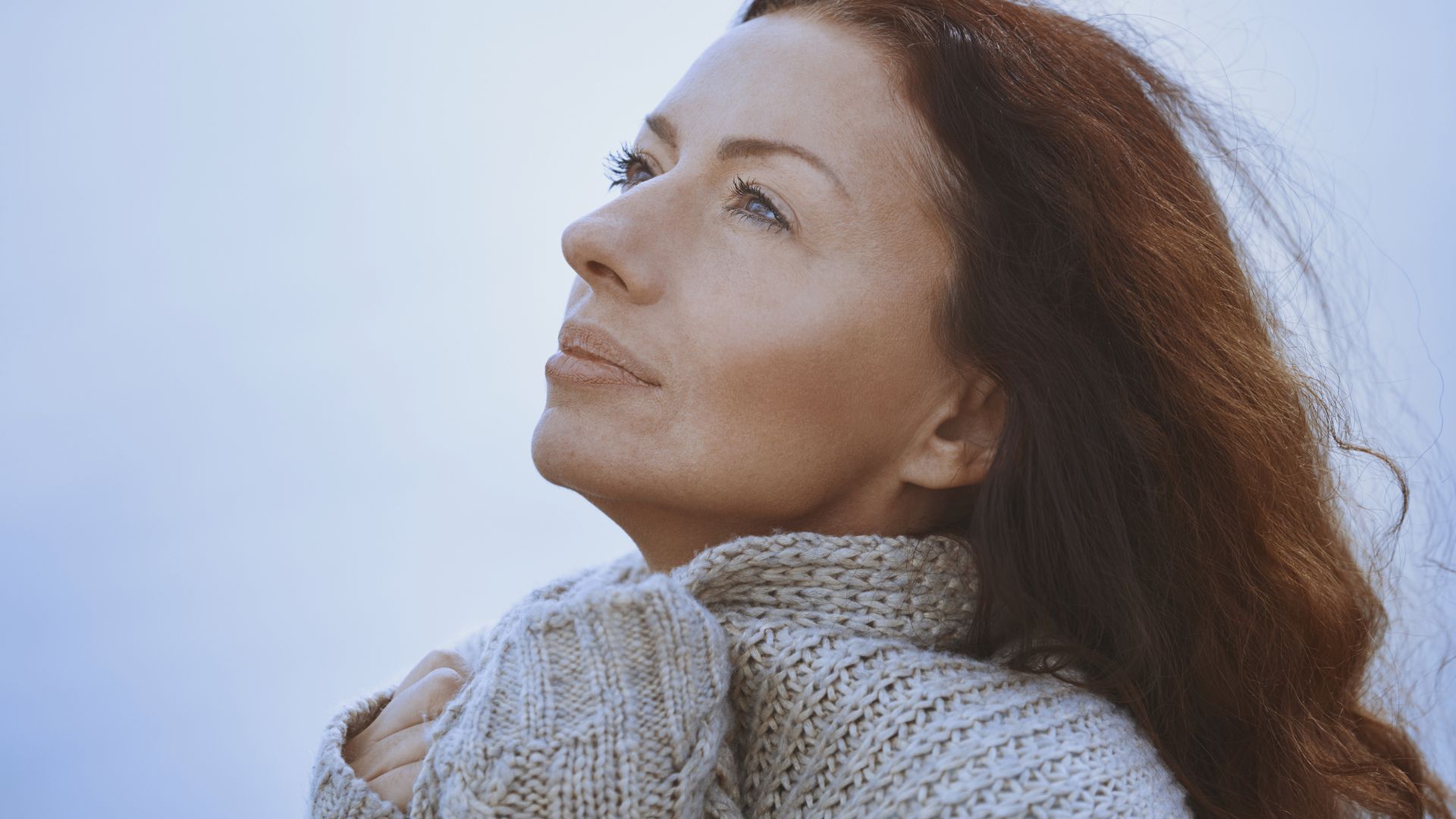 Pensive serene woman at seaside with eyes open