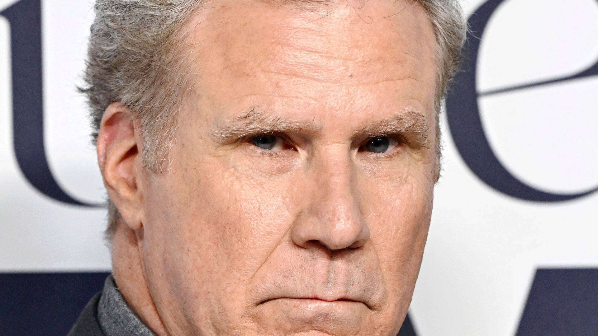 Will Ferrell with a glum expression in a black suit