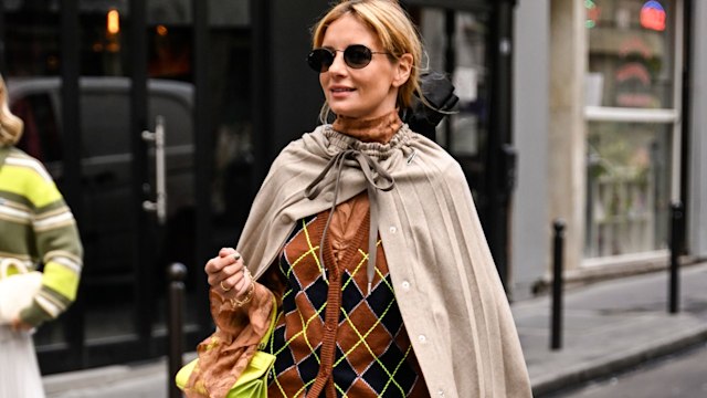  A guest is seen wearing a cape, brown and lime green cardigan, lime green bag, black socks and brown shoes outside the Lacoste show during Womenswear Spring/Summer 2025 as part of Paris Fashion Week on October 01, 2024 in Paris, France. (Photo by Daniel Zuchnik/Getty Images)