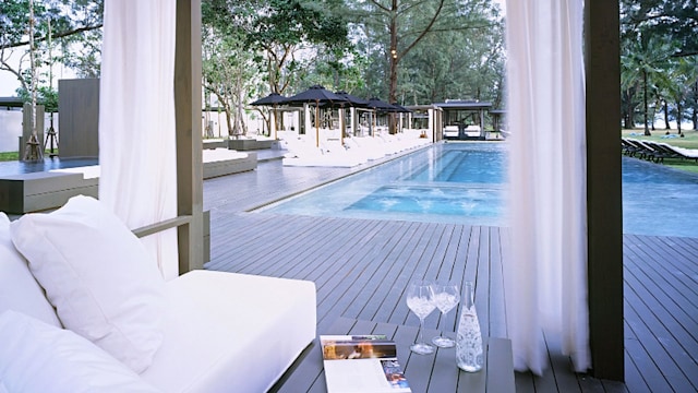 outdoor furniture under pergola looking at pool