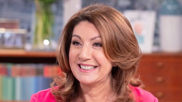 Jane McDonald smiling in a pink blouse