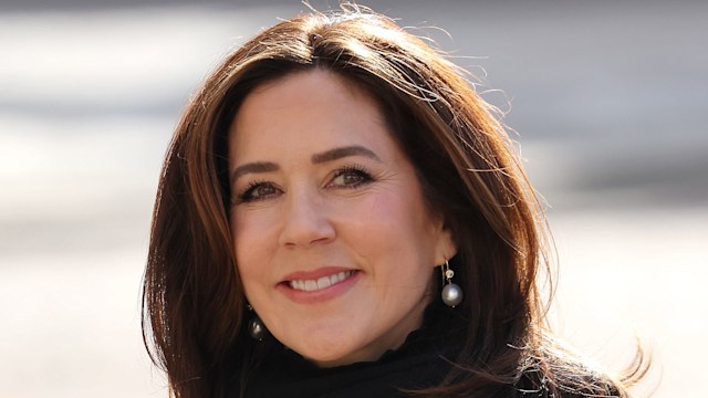 Princess Mary wearing a black scarf with a white woven coat and pearl earrings 