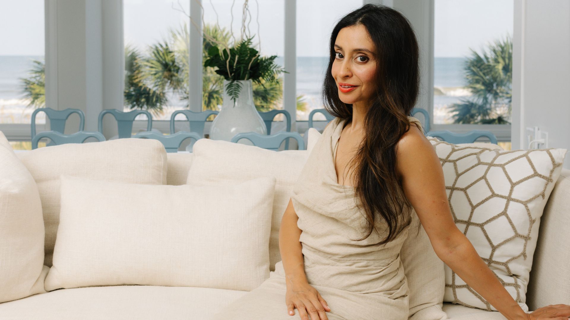dark haired woman sitting on a cream sofa