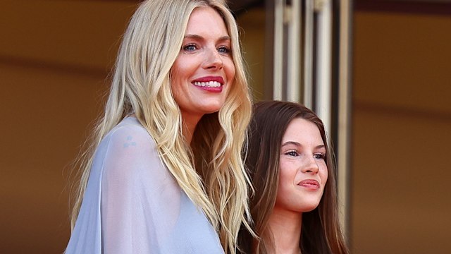 Sienna Miller in a blue dress smiling with her daughter Marlowe