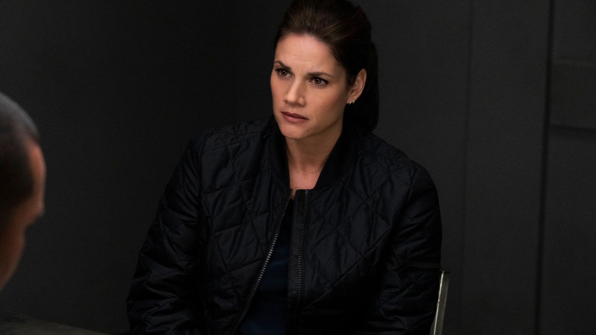 Missy Peregrym sits at a table in an episode of FBI