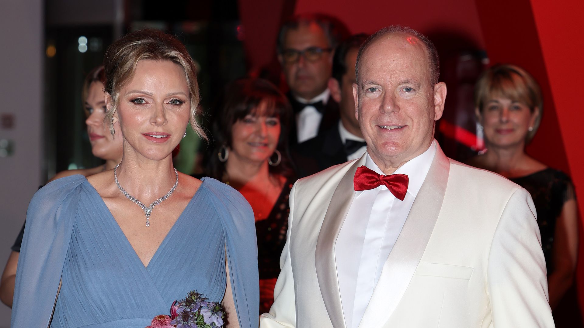 Princess Charlene in a blue dress with Prince Albert in a white dress