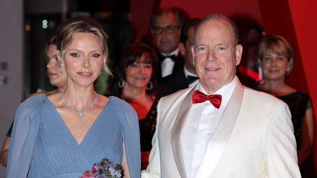 Princess Charlene in a blue dress with Prince Albert in a white dress