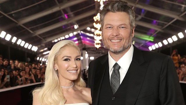 Gwen Stefani in white dress and Blake Shelton in suit smiling