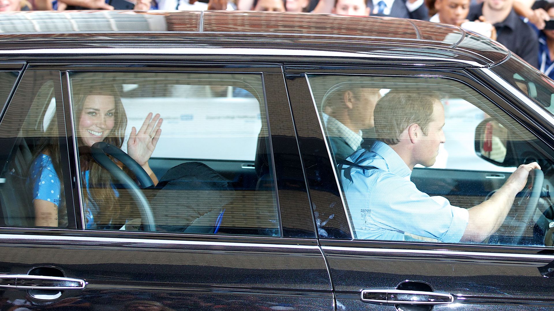 Prince William driving while Kate Middleton sits in the back with Prince George