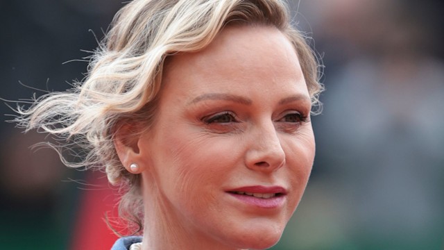 Princess Charlene looks to right in blazer and pearls