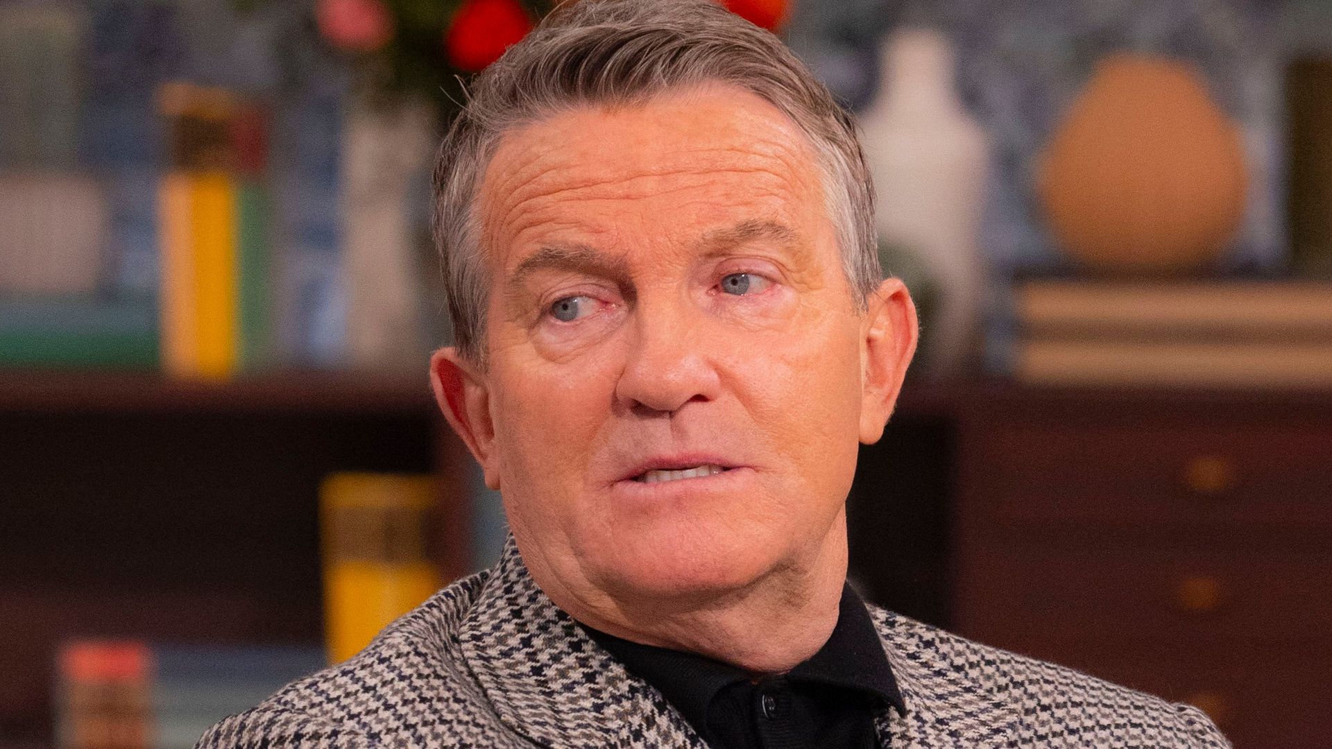 man sat cross armed on chair 