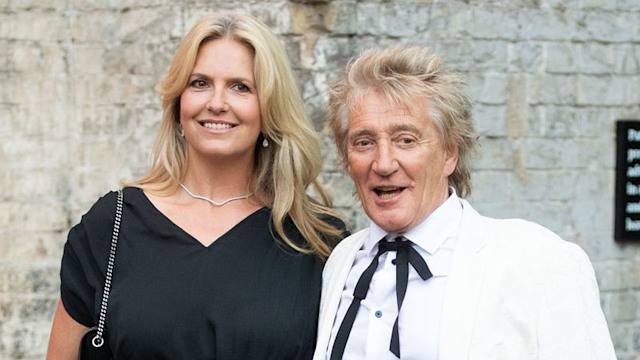 Penny Lancaster and Rod Stewart smile as they pose together. 
