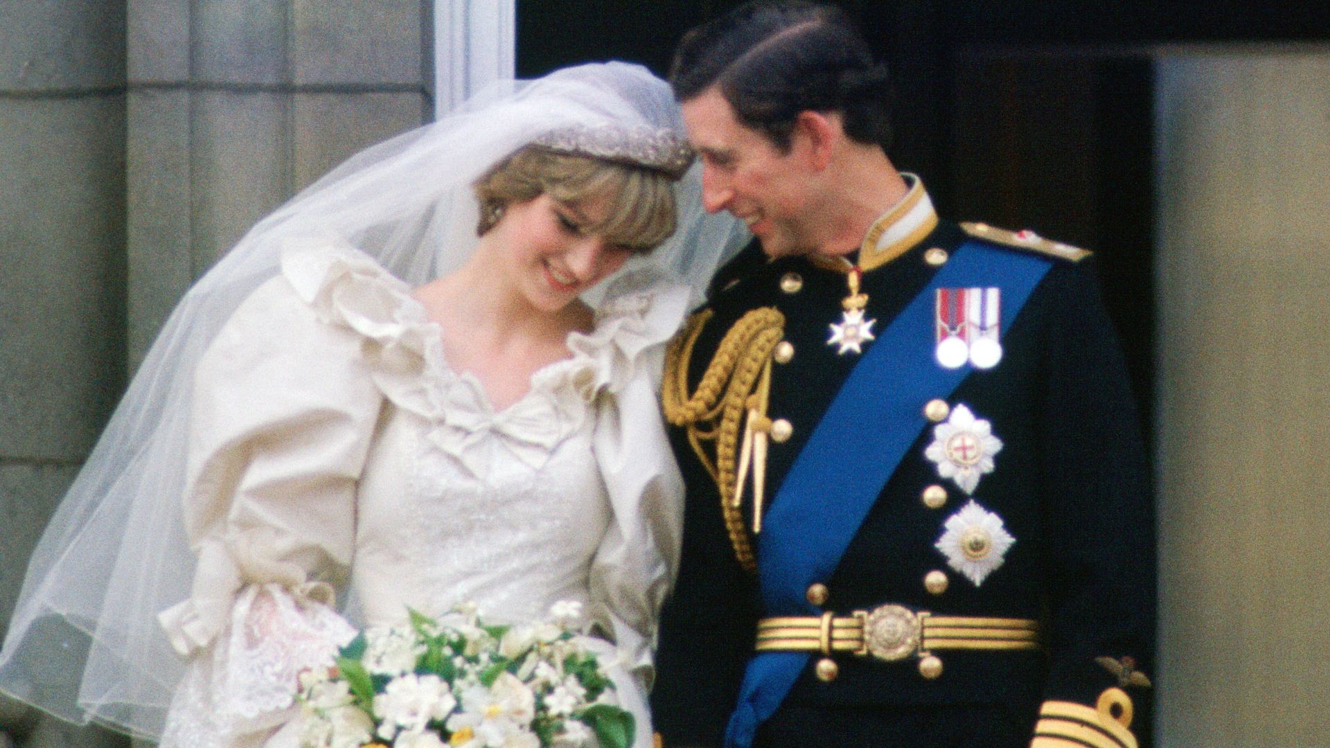 Prince Charles whispering to Diana on their wedding day on the balcony of Buckingham Palace