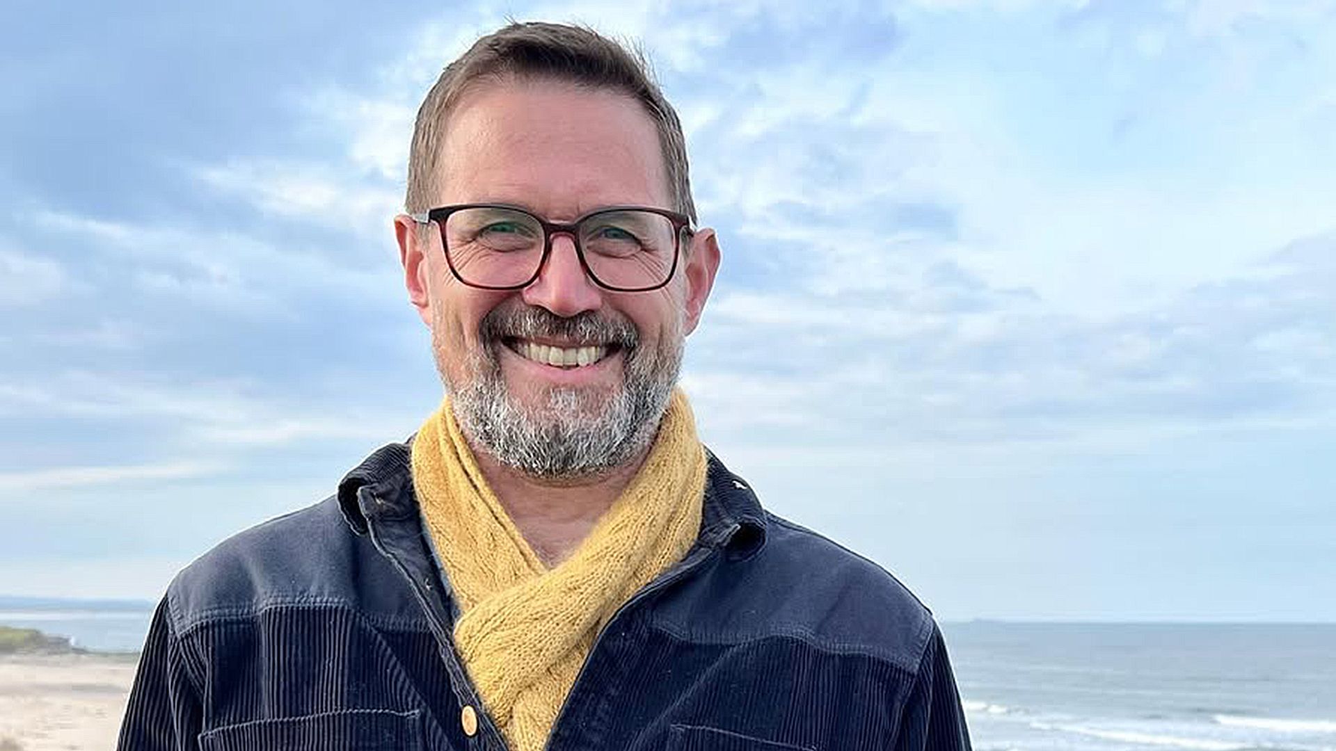 Alistair Appleton smiling on a beach