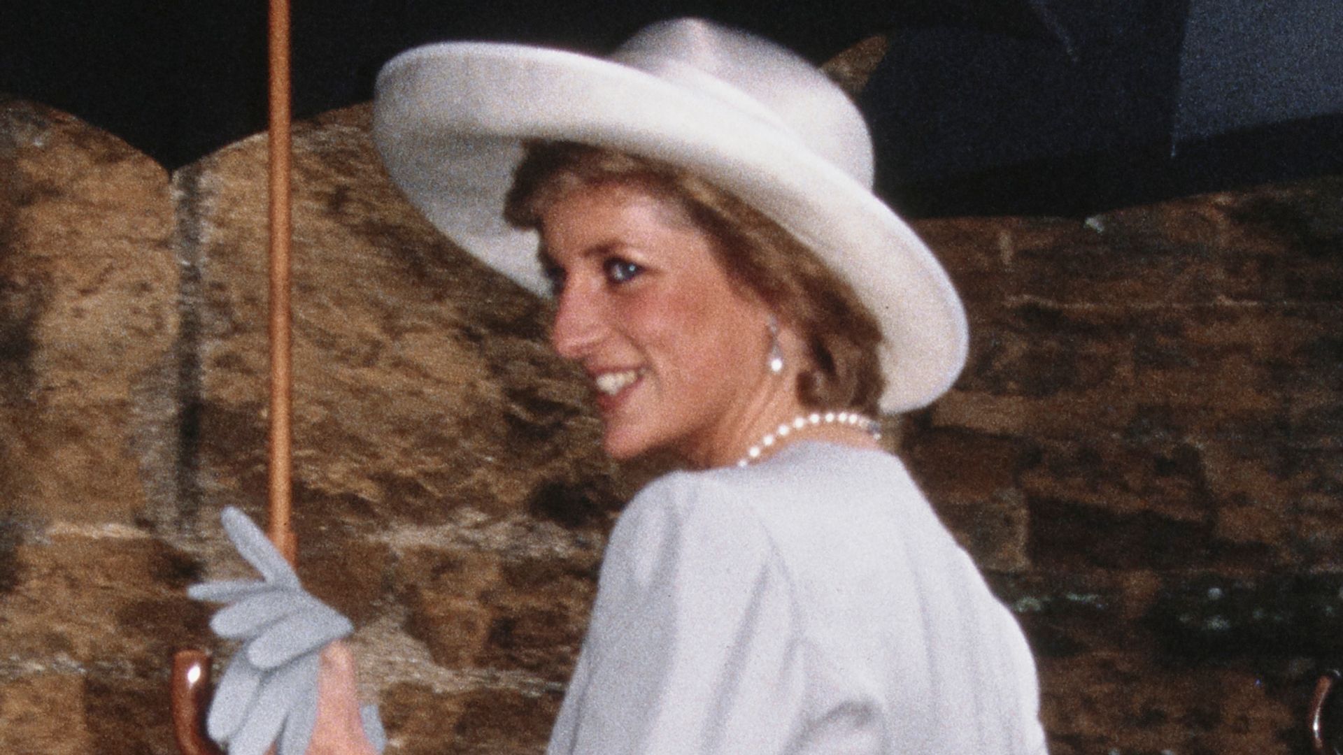 Princess Diana looking over her shoulder in a grey coat