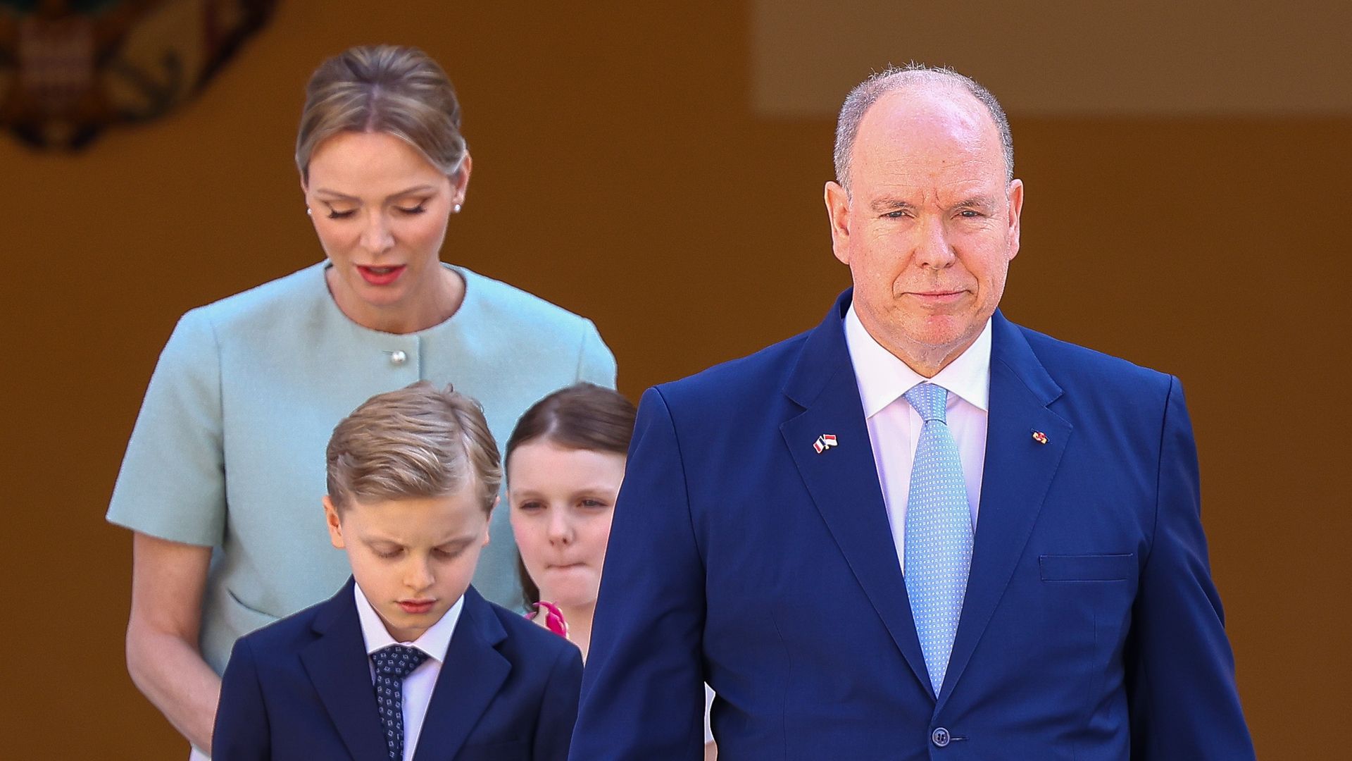 Prince Albert walking with Prince Jacques, Princess Gabriella and Princess Charlene behind him