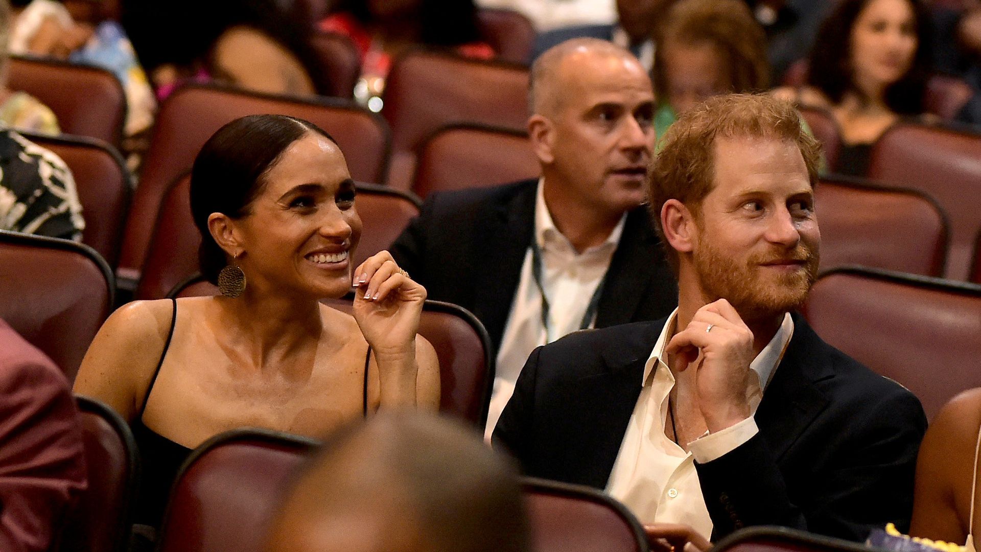 Meghan Markle and Prince Harry sitting in movie chairs