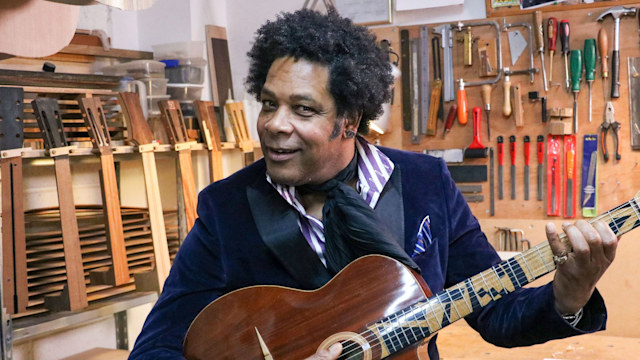 Man playing jazz guitar in workshop