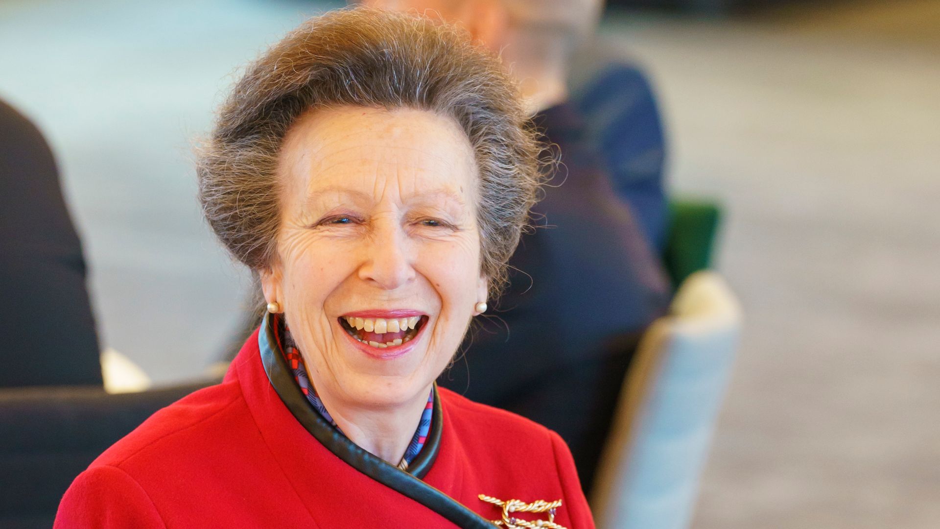 Princess Anne laughing in red coat