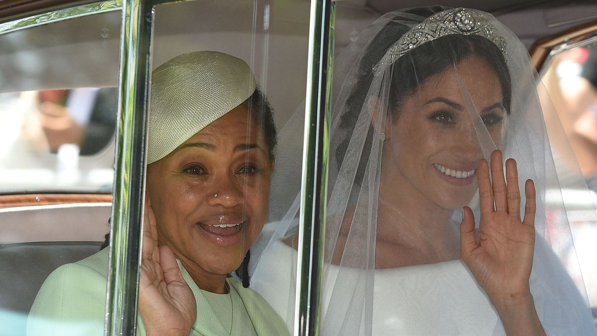 Meghan Markle waving in the car with her Doria Ragland arrive for her wedding ceremony