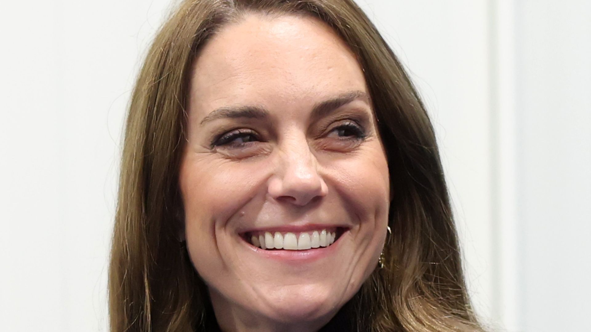 Catherine, Princess of Wales smiling to right in rollneck sweater