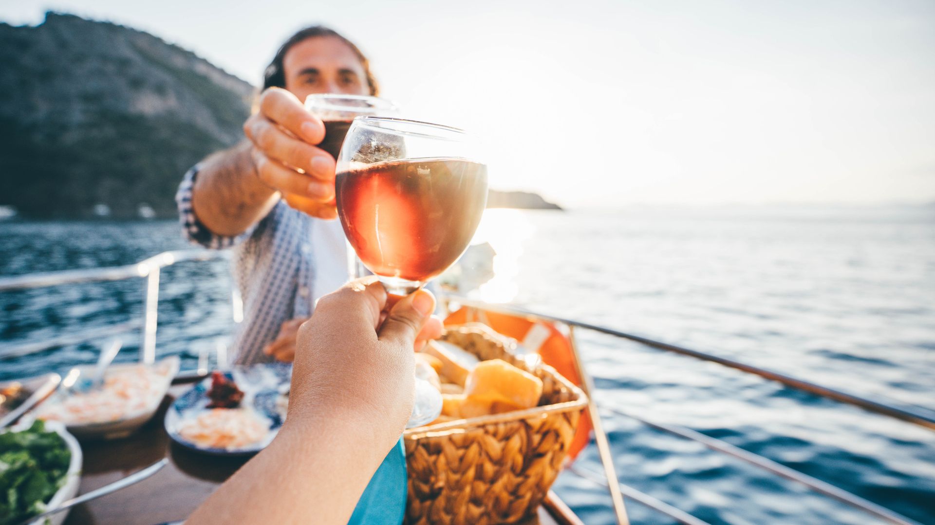 Friend drinking wine on the yacht at sunset. Toasting on a yacht.